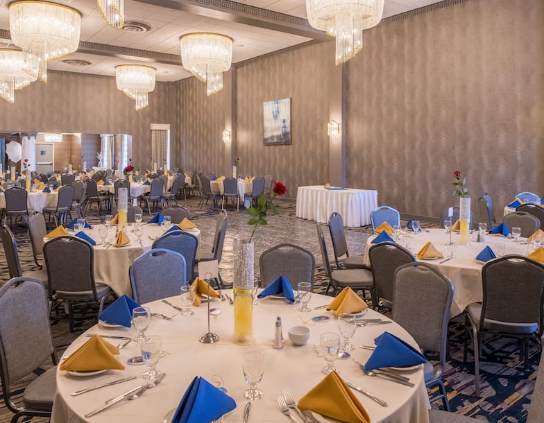 Spacious Ballroom Area with Round Tables and Chairs 